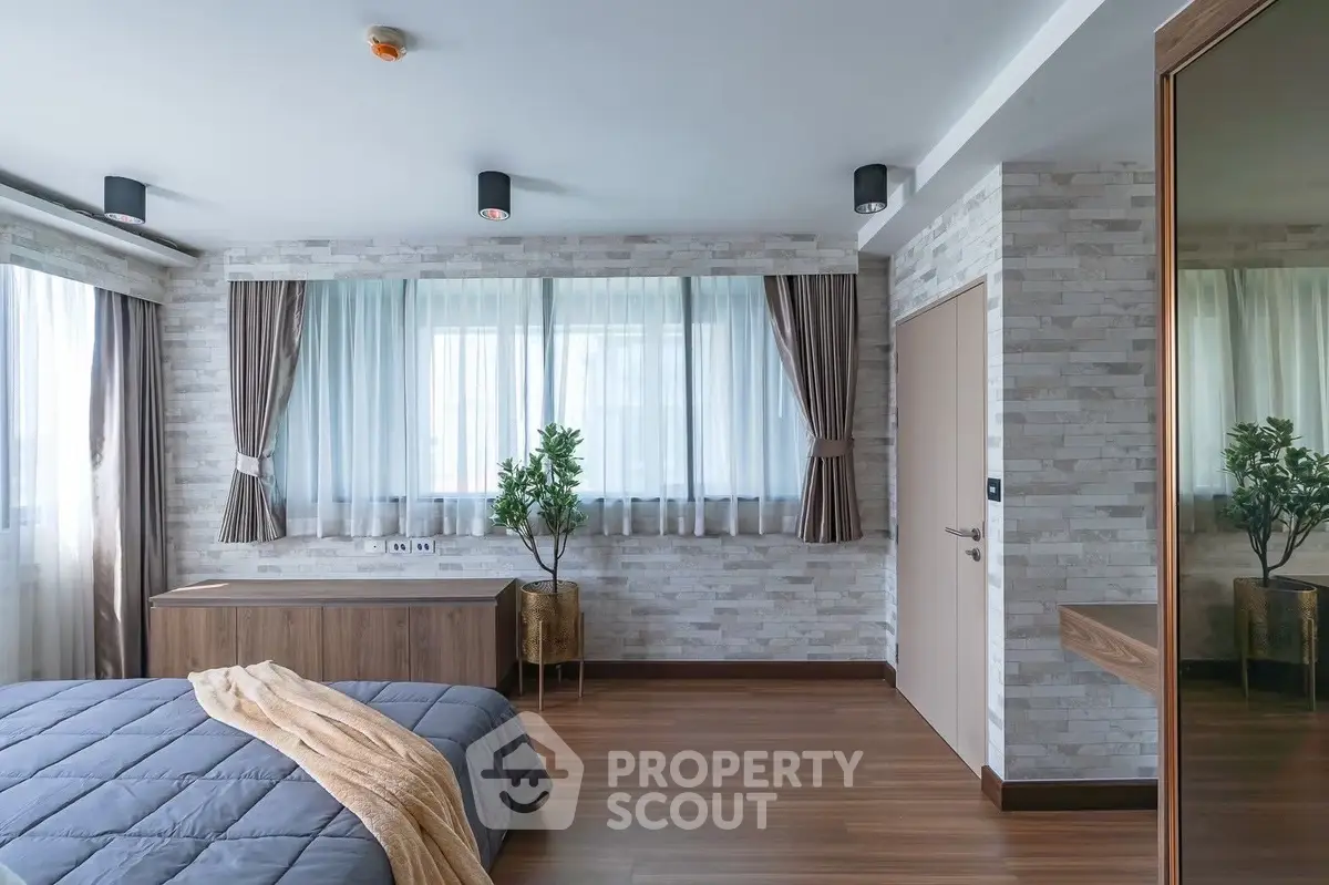 Modern bedroom with stylish decor and large windows for natural light
