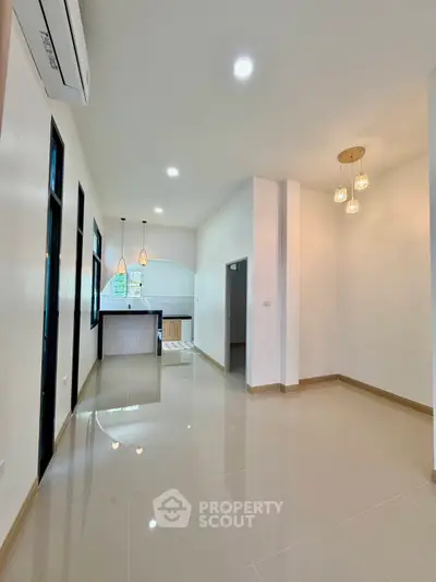 Modern open-plan living area with sleek kitchen and elegant lighting