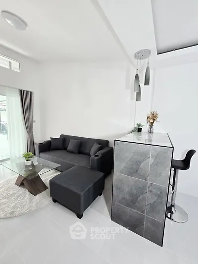 Modern living room with sleek gray sofa and stylish bar area, perfect for entertaining guests.