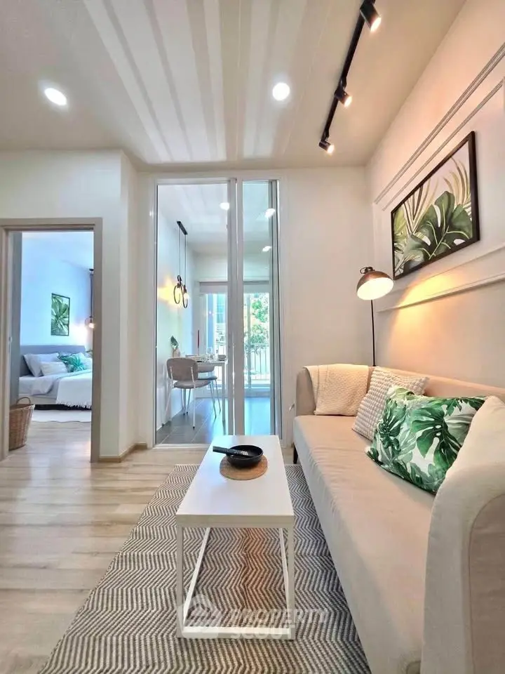 Modern living room with stylish decor and natural light, featuring a cozy sofa and elegant lighting.