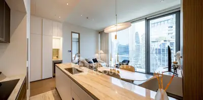 Luxurious open-plan kitchen and living room with stunning city view, modern design, and elegant furnishings.