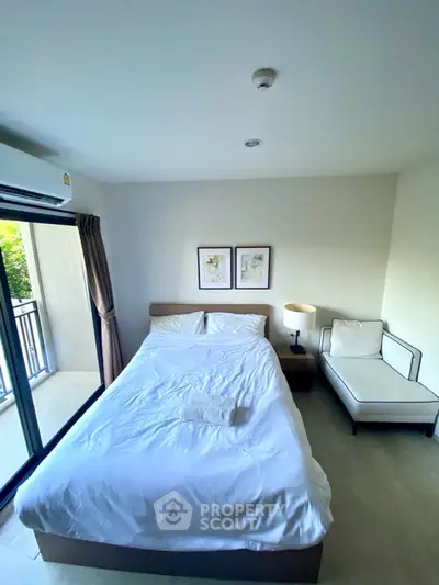 Cozy bedroom with balcony access and modern decor in a bright apartment.