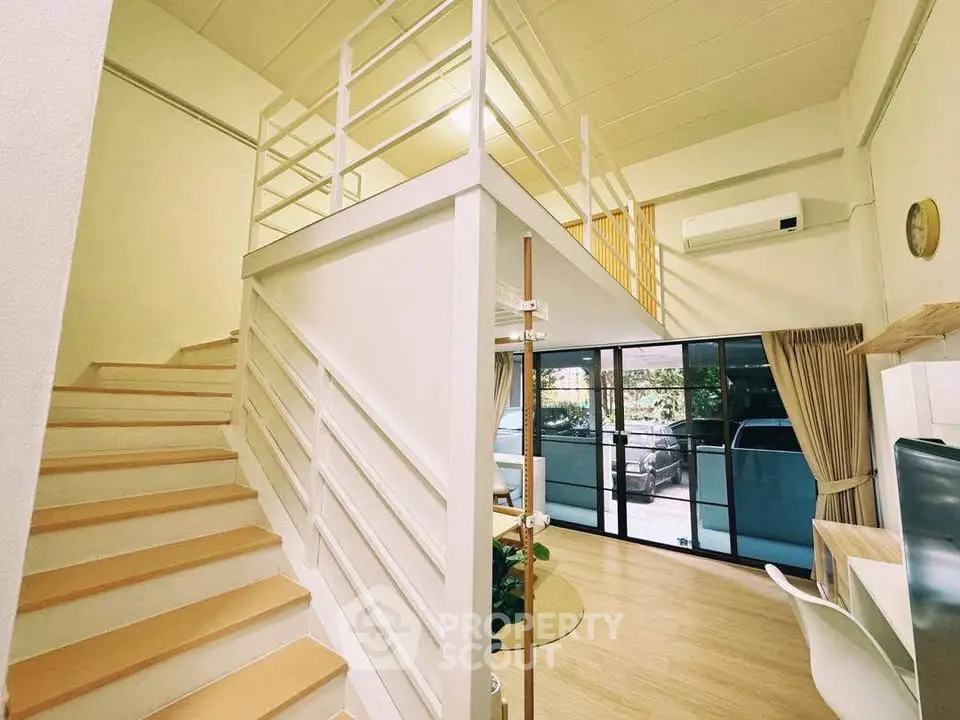 Modern loft apartment with mezzanine, open layout, and large windows for natural light.