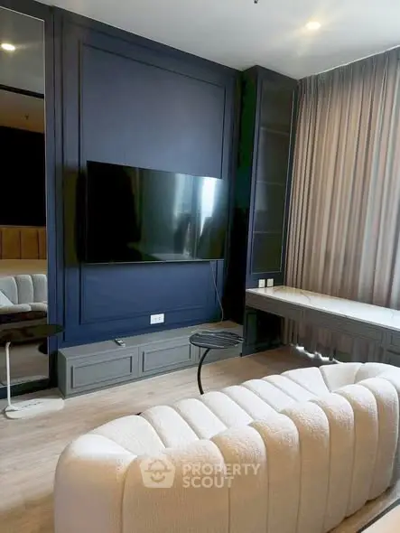 Modern living room with plush sofa and wall-mounted TV in stylish apartment.