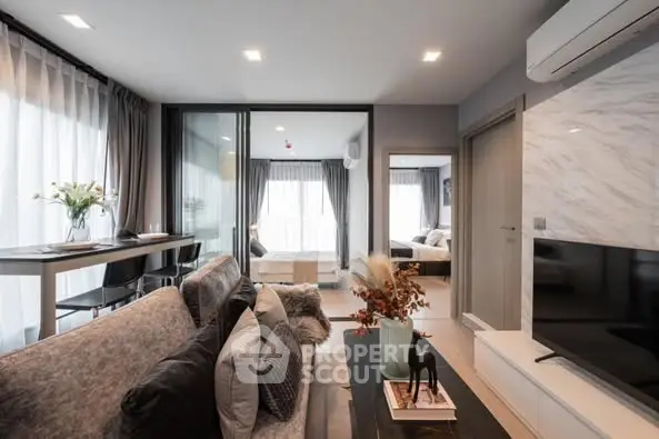 Modern living room with stylish decor and open layout, featuring a cozy seating area and large windows.
