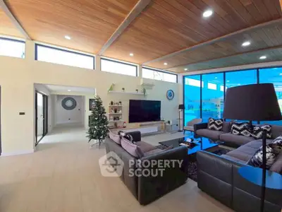 Spacious modern living room with high ceilings and large windows offering natural light.