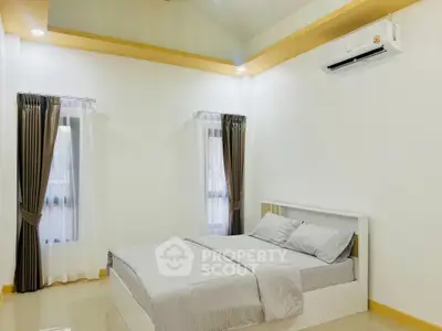 Spacious bedroom with modern decor and air conditioning in a well-lit room.