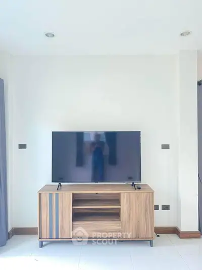 Modern living room with sleek TV stand and large flat-screen television