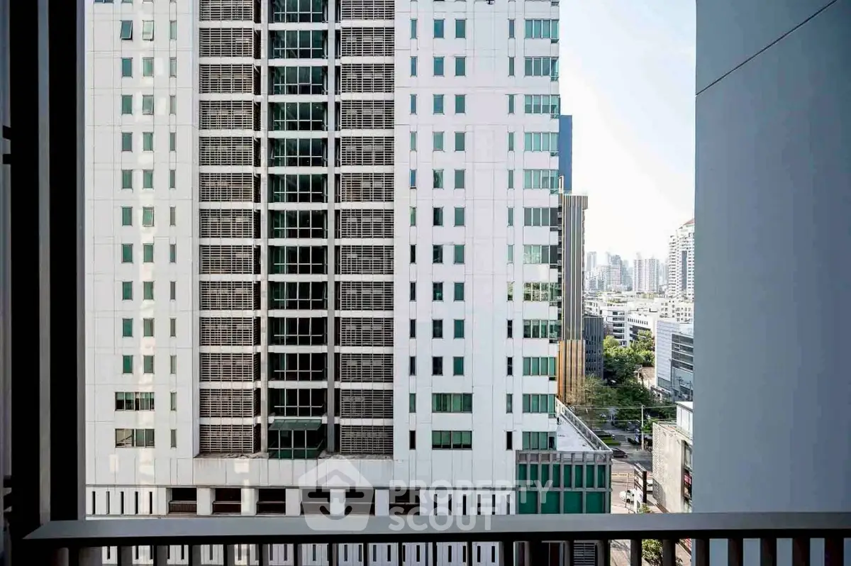 Stunning urban view from a high-rise balcony overlooking city skyline and modern architecture.