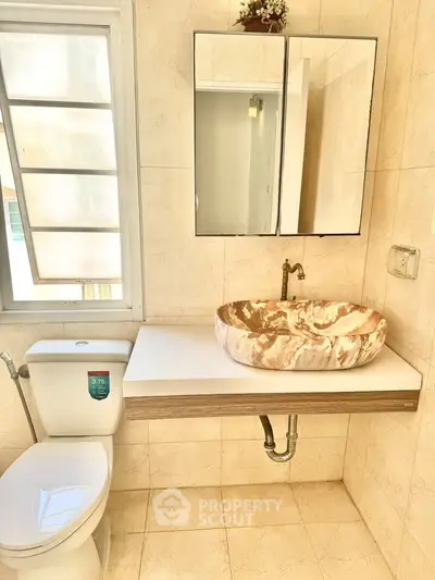 Stylish bathroom with unique marble sink and modern fixtures