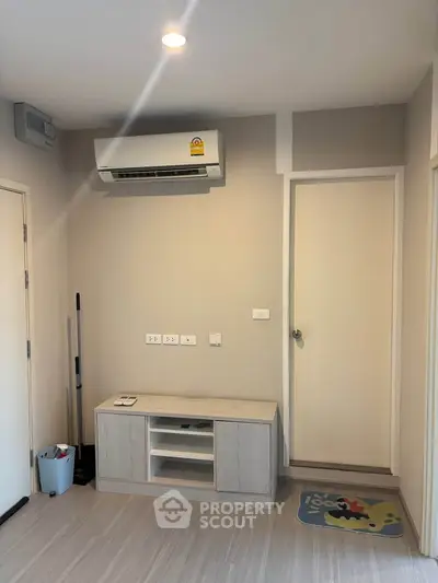 Modern minimalist living room with air conditioning and sleek storage unit.