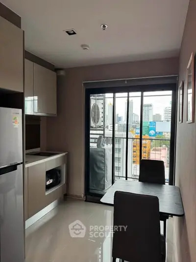 Modern kitchen with city view, featuring sleek cabinetry and dining area in a high-rise apartment.