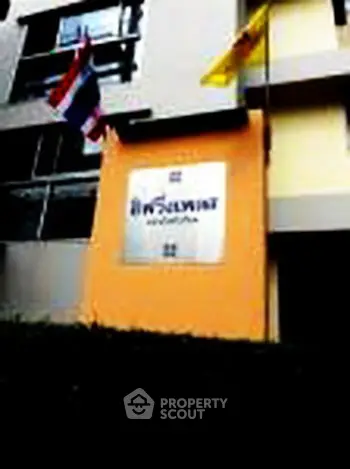 Modern building exterior with flags and signage, ideal for urban living.