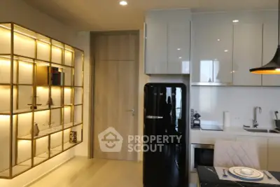 Modern kitchen with sleek appliances and stylish shelving in a contemporary apartment.