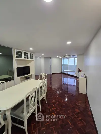 Spacious living room with elegant dining area and polished wooden floors.