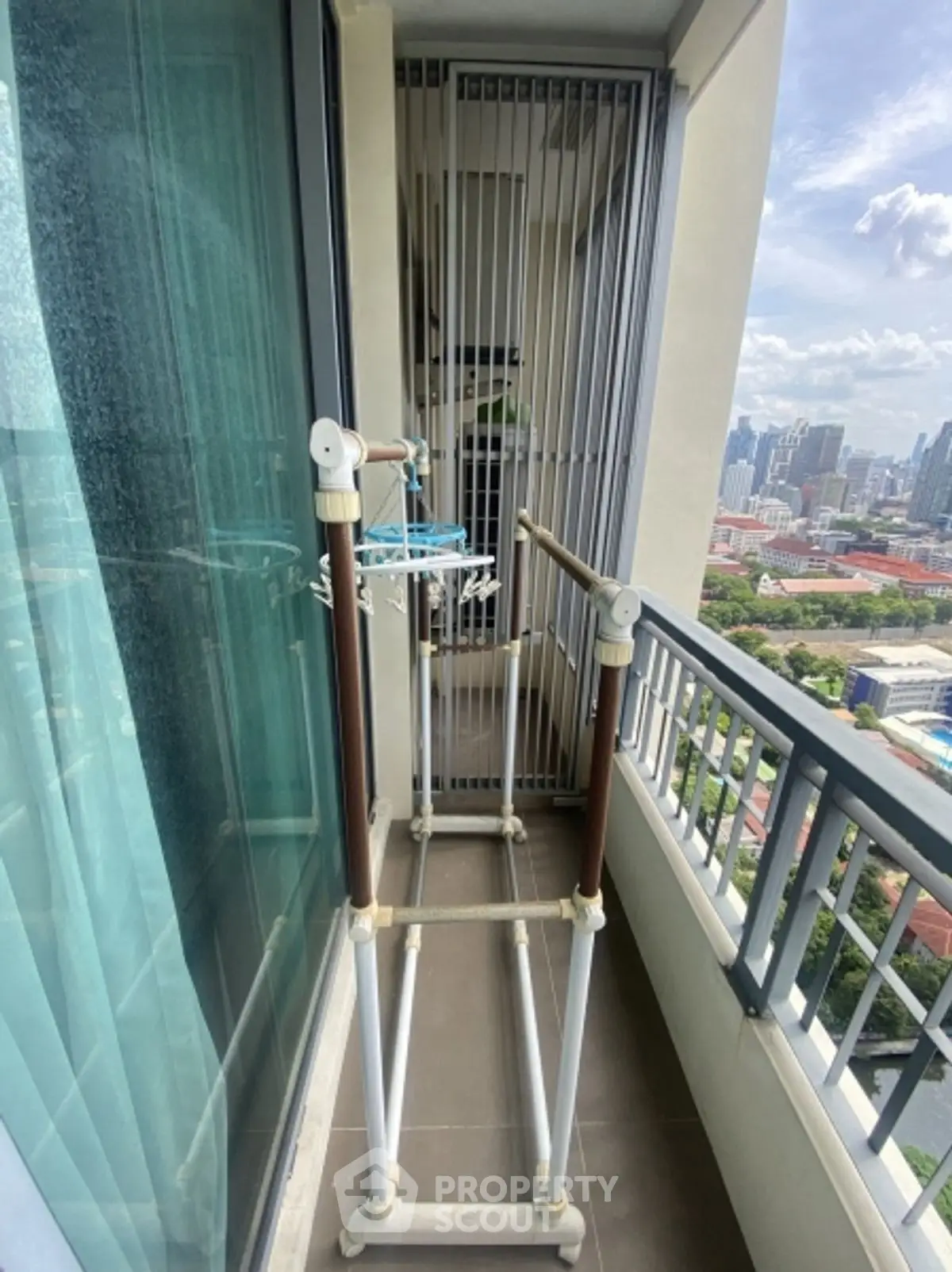 High-rise balcony with city view and drying rack, perfect for urban living.