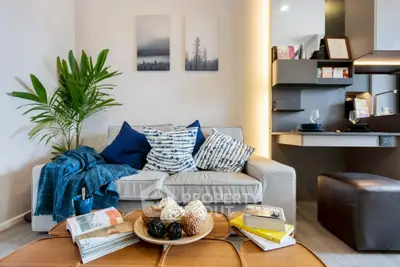 Stylish living room with cozy sofa, modern decor, and open kitchen layout.