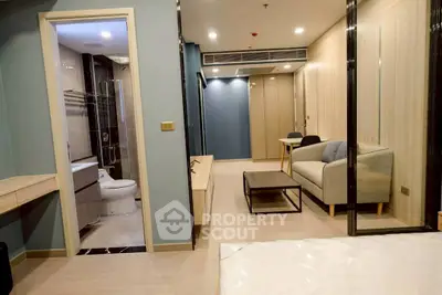 Modern apartment interior with living room and bathroom, featuring sleek design and cozy furnishings.