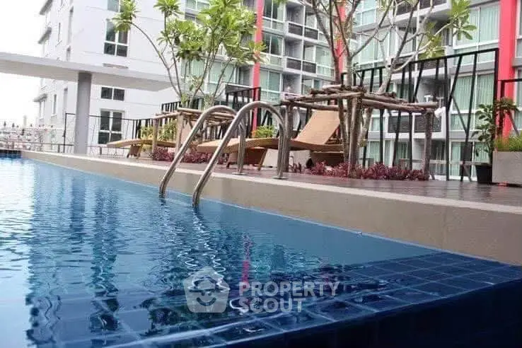 Luxurious apartment complex with inviting pool and modern design.