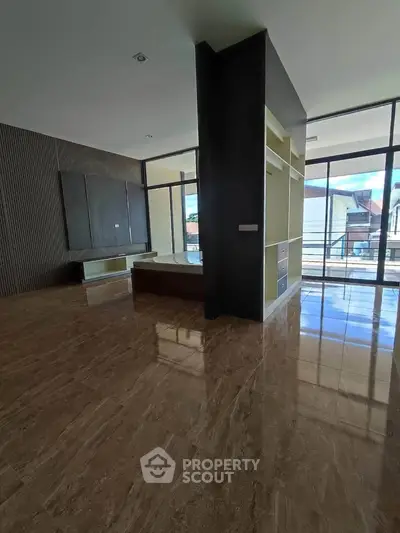 Spacious modern living room with large windows and glossy marble flooring