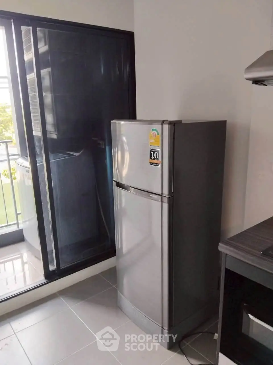 Modern kitchen with sleek stainless steel fridge and balcony view