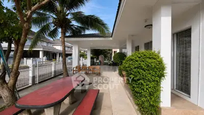 Charming outdoor patio with lush greenery and seating area in a modern residential property.