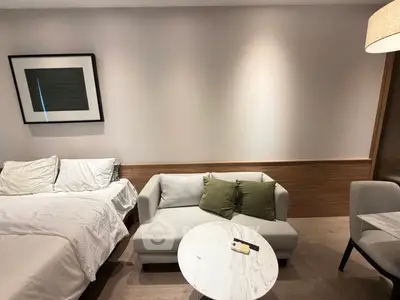 Modern studio apartment with cozy bed, stylish sofa, and elegant decor