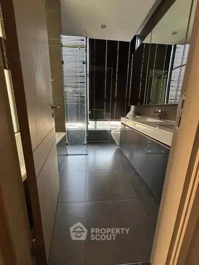 Modern bathroom with sleek design, featuring large mirrors and contemporary fixtures.