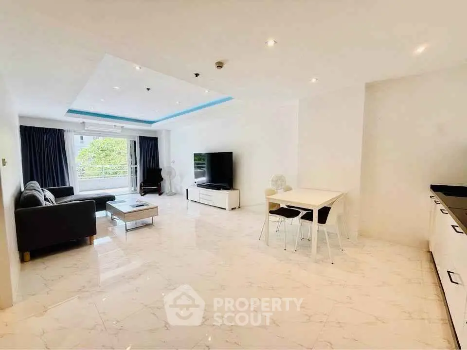 Spacious modern living room with sleek furniture and large windows offering natural light.