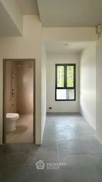 Minimalist bathroom with modern fixtures and large window for natural light.