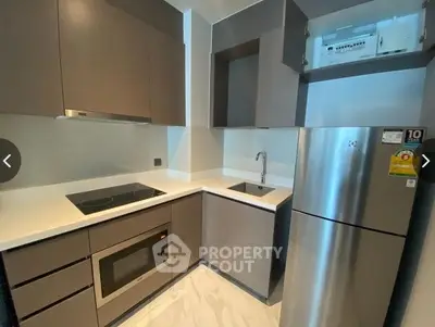 Sleek modern kitchen with stainless steel appliances, ample cabinetry, and a built-in oven, perfect for culinary enthusiasts.
