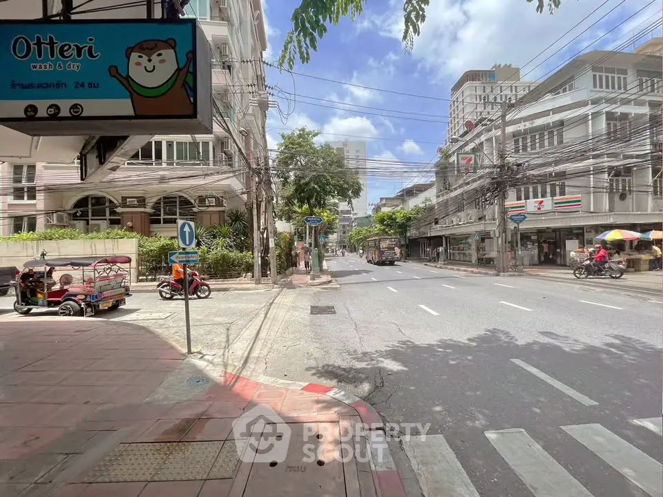 Street view with buildings and shops in a bustling urban area, showcasing vibrant city life.