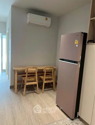 Cozy kitchen corner with modern fridge and dining set in a stylish apartment.