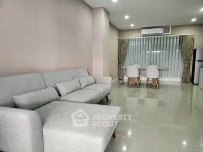 Modern living room with sleek grey sofa and dining area, perfect for contemporary living.