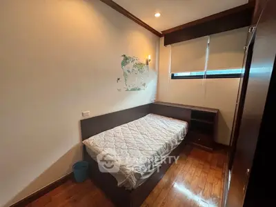 Cozy bedroom with wooden flooring and natural light