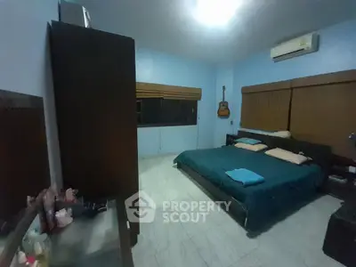 Spacious bedroom with modern decor and wall-mounted guitar