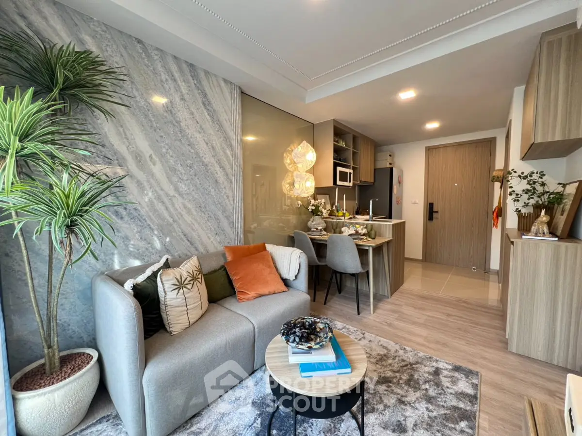 Modern living room with open kitchen, stylish decor, and cozy seating area in a contemporary apartment.