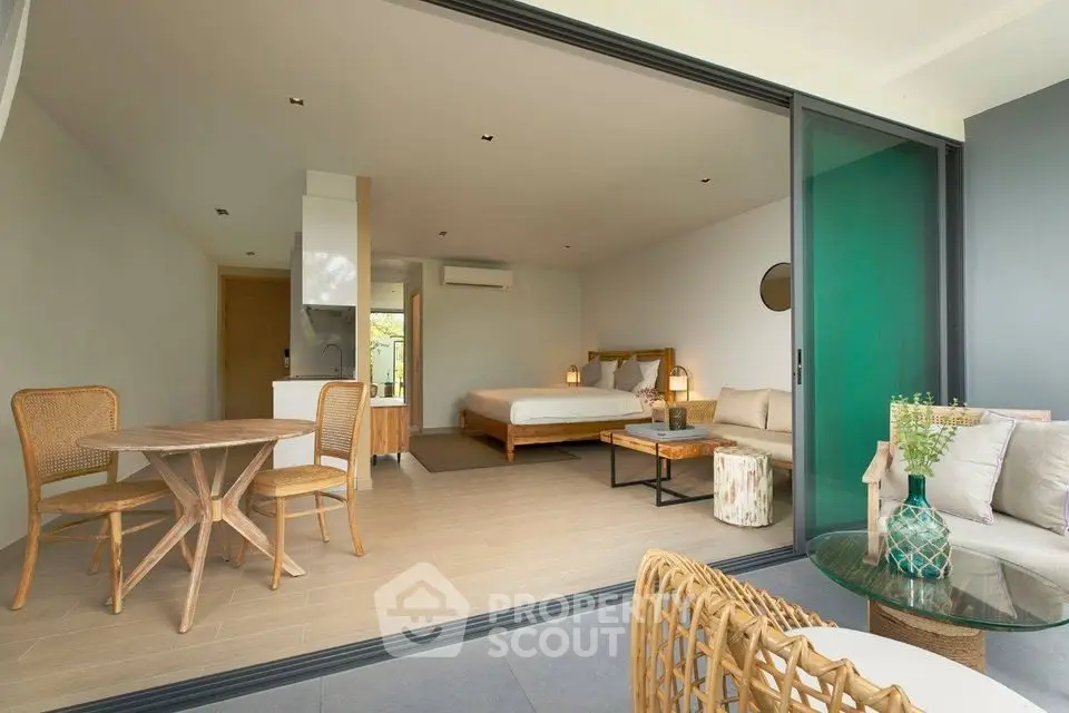 Spacious open-plan living room with modern decor and large sliding glass doors to balcony.