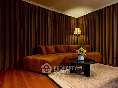 Cozy living room with plush brown sofa, elegant lamp, and stylish coffee table on a chic rug.
