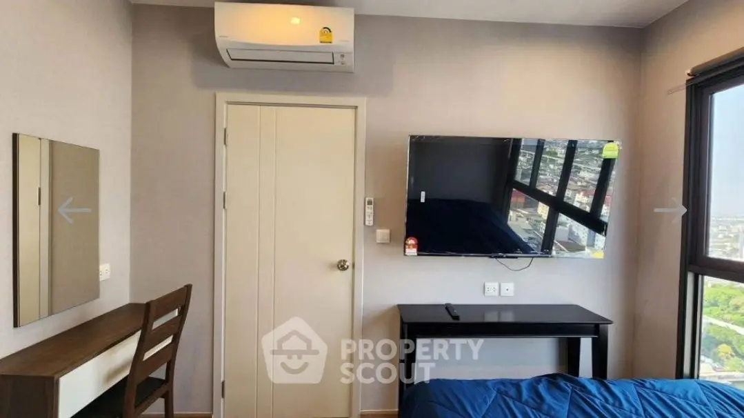 Modern bedroom with wall-mounted TV and air conditioning, featuring a sleek desk and large window view.