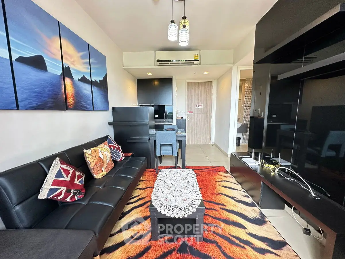Stylish living room with modern decor and vibrant rug in a cozy apartment setting.