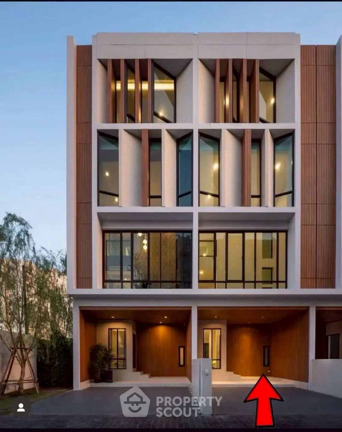 Modern multi-story townhouse with unique architectural design and large windows.