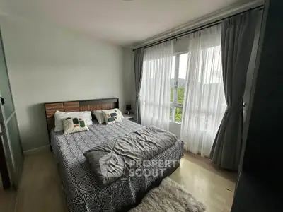 Cozy bedroom with large window and stylish decor in modern apartment