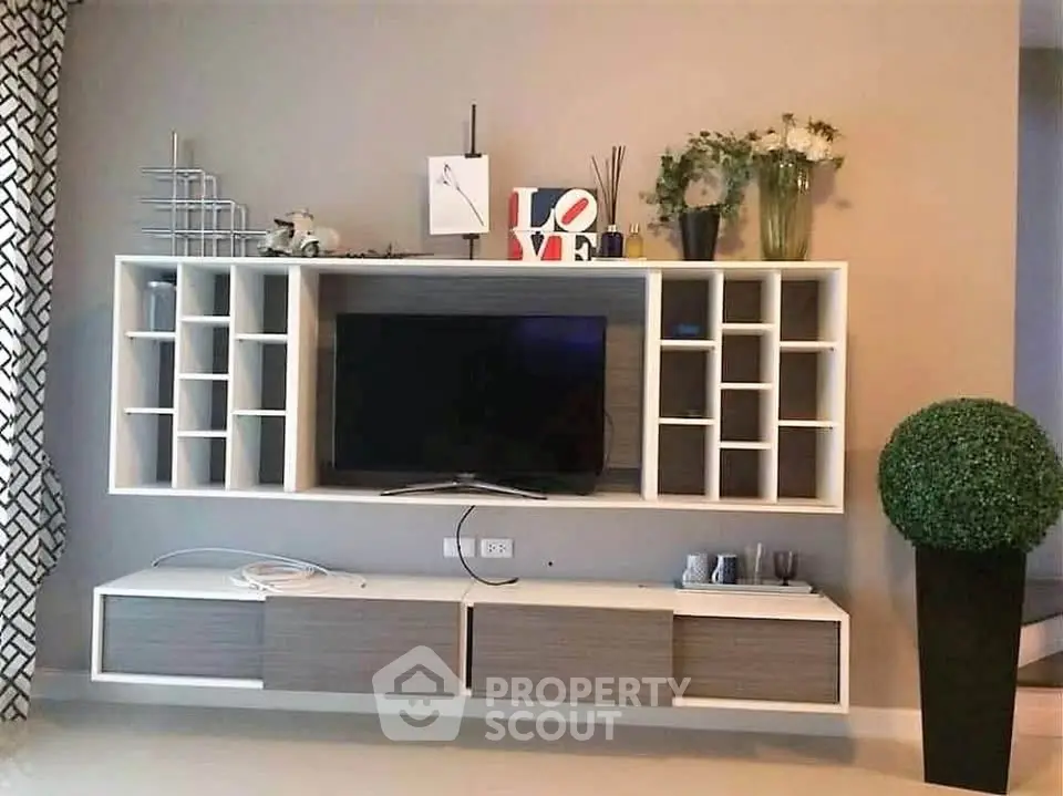 Modern living room with stylish wall-mounted entertainment unit and decorative elements.