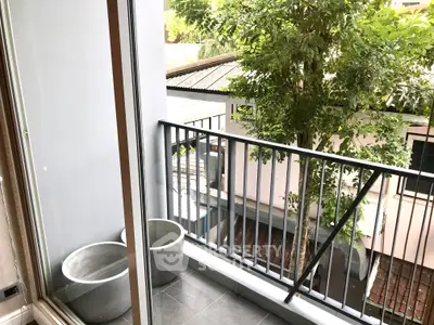 Charming balcony with lush greenery and modern railing, perfect for relaxation.