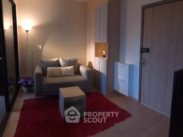 Cozy living room with modern decor and warm lighting, featuring a comfortable sofa and stylish rug.