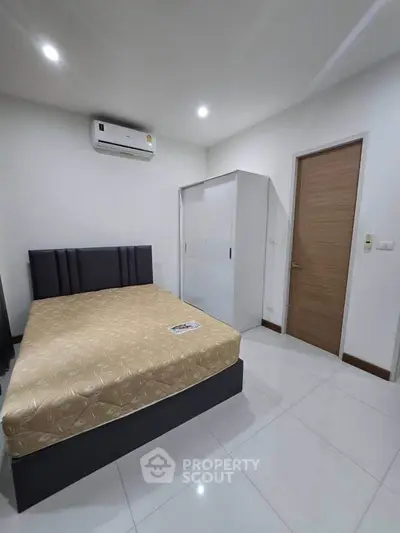 Modern bedroom with sleek design and air conditioning, featuring a comfortable bed and spacious wardrobe.