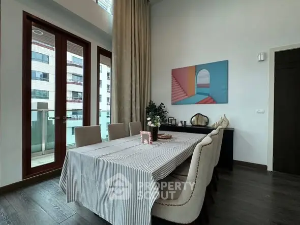 Elegant dining area with modern decor and large windows in a stylish apartment.