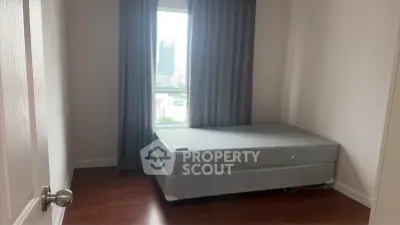 Cozy bedroom with large window and hardwood floors, perfect for natural light lovers.
