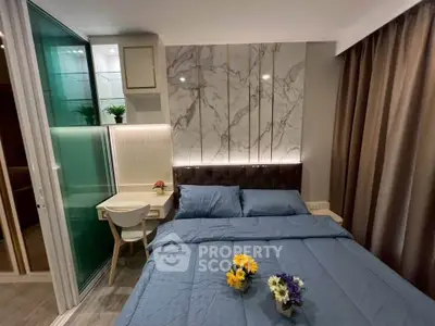 Modern bedroom with elegant marble accent wall and cozy blue bedding